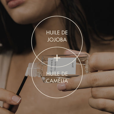 Cleansing Oil à l'huile de jojoba et de camélia tenue en main avec un applicateur