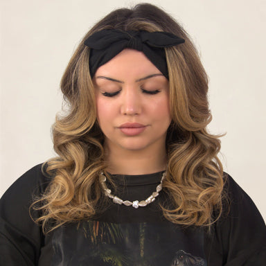 Femme blonde au bandeau noir, regard baissé sur ses faux cils GLAMOUR