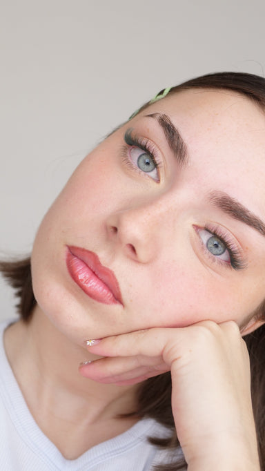 Femme pensive menton sur la main, faux cils de couleur posés